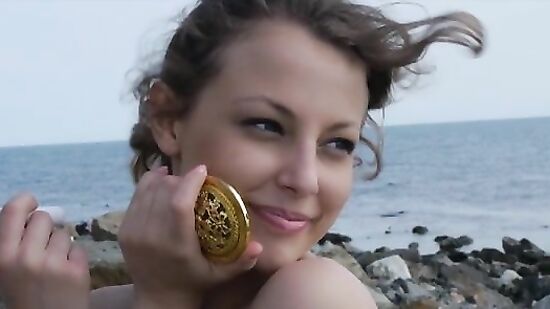 Голая красотка позирует фотографу на берегу моря